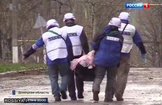 OSCE observers remove a body in Shyrokyne