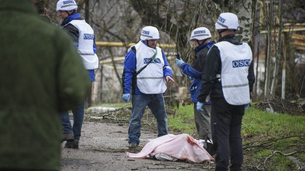 Сотрудники миссии ОБСЕ вокруг тела погибшего на востоке Украины 