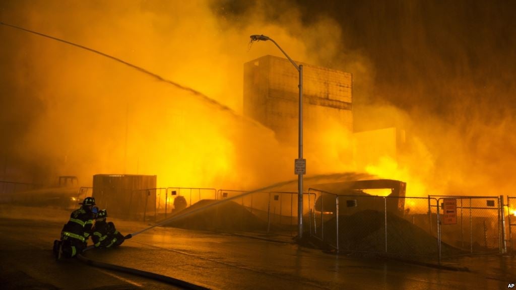 Firefighters battle a blaze, after rioters plunged part of Baltimore into chaos, torching a pharmacy, setting police cars ablaze and throwing bricks at officers, April 27, 2015.