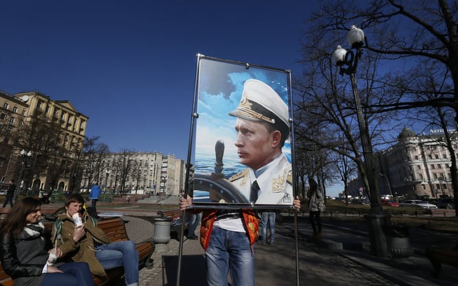 epaselect epa04664779 An activist of the Anti-Maidan movement installs an artwork representing Russian President Vladimir Putin during an outdoor exhibition entitled 'Crimea: Return to Home Port', in Moscow, Russia 16 March 2015. The exposition is devoted to the anniversary of the referendum in which the people voted for the Crimea entry into the Russian Federation.  EPA/YURI KOCHETKOV
