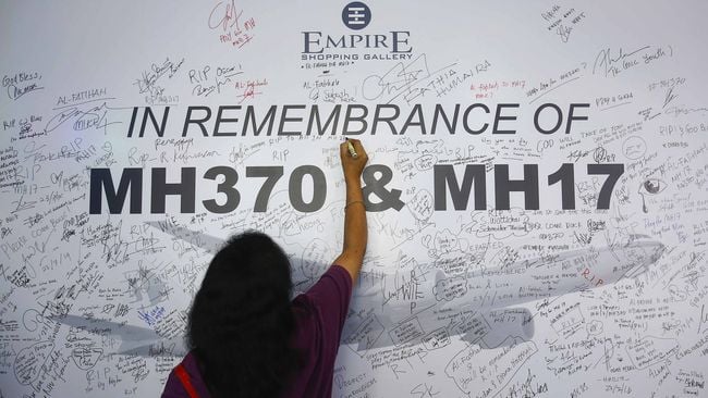 A woman writes a message on a dedication board for the victims of the downed Malaysia Airlines Flight MH17 airliner and the missing Flight MH370, in Subang Jaya outside Kuala Lumpur July 23, 2014. All sides in Ukraine's civil war must protect civilians and take what measures they can to search for the victims of downed Malaysia Airlines flight MH17 airliner and ensure their bodies are returned, the International Committee of the Red Cross said on Wednesday.REUTERS/Samsul Said (MALAYSIA - Tags: DISASTER TRANSPORT POLITICS SOCIETY)