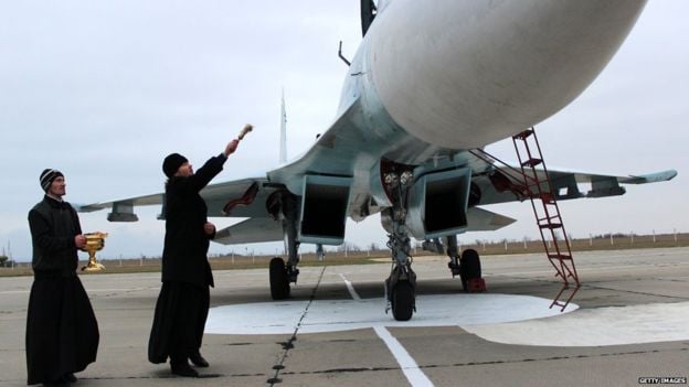 A Russian Orthodox priest blesses a fighter jet 