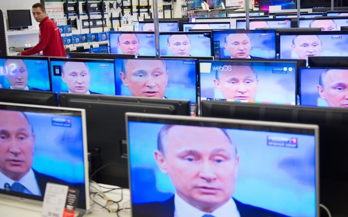 An employee stands by TV sets in a shop in Moscow on April 16, 2015 during the broadcast of Russian President Vladimir Putin's annual televised phone-in with the nation. AFP PHOTO / ALEXANDER UTKIN        (Photo credit should read ALEXANDER UTKIN/AFP/Getty Images)