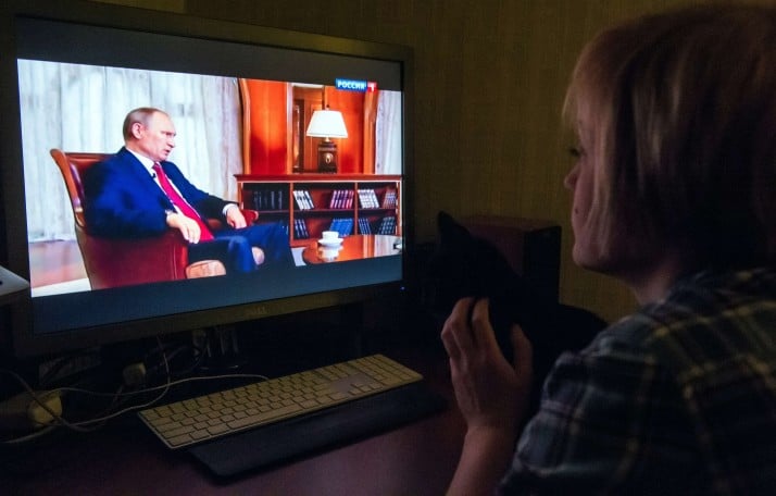 TO GO WITH AFP STORY BY FRAN BLANDY A woman looks at Russian President Vladimir Putin speaking as she watches an internet broadcast of the documentary "Homeward Bound", on March 15, 2015 in Moscow. Putin said he was ready to put the country's nuclear forces on alert as he sought to annex Crimea last year after the fall of a Moscow-backed government in Kiev. Speaking in a documentary aired on state TV in Russia on March 15, 2015, a year after the takeover of the Black Sea Peninsula from Ukraine, Putin showed the lengths he was willing to go to in order to protect Russian-speaking citizens of the province he considered a historic slice of Russia. AFP PHOTO / DMITRY SEREBRYAKOV        (Photo credit should read DMITRY SEREBRYAKOV/AFP/Getty Images)