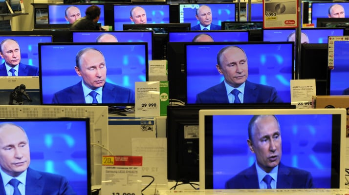 A customer walks past the TV screens in a shop in Moscow, on April 25, 2013, during the broadcast of President Vladimir Putin's televised question and answer session with the nation. AFP PHOTO / ANDREY SMIRNOV        (Photo credit should read ANDREY SMIRNOV/AFP/Getty Images)