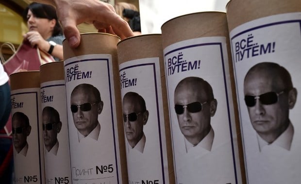 This picture taken on August 11, 2014 shows boxes of T-shirts with portraits of Russia's President Vladimir Putin, in a shop in central Moscow. The sale of a new collection of T-shirts with Putin's portrait starts in the Russian capital on August 11, at a price of 1200 rubles (25 euros).  AFP PHOTO 