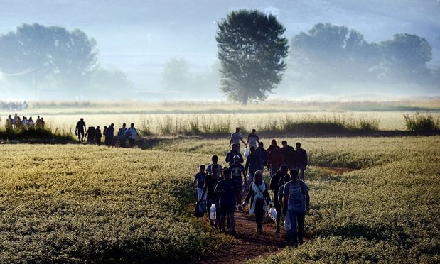 Syrian refugees cross the border between Greece and Macedonia in 2015. Photograph: Aris Messinis/AFP/Getty Images 