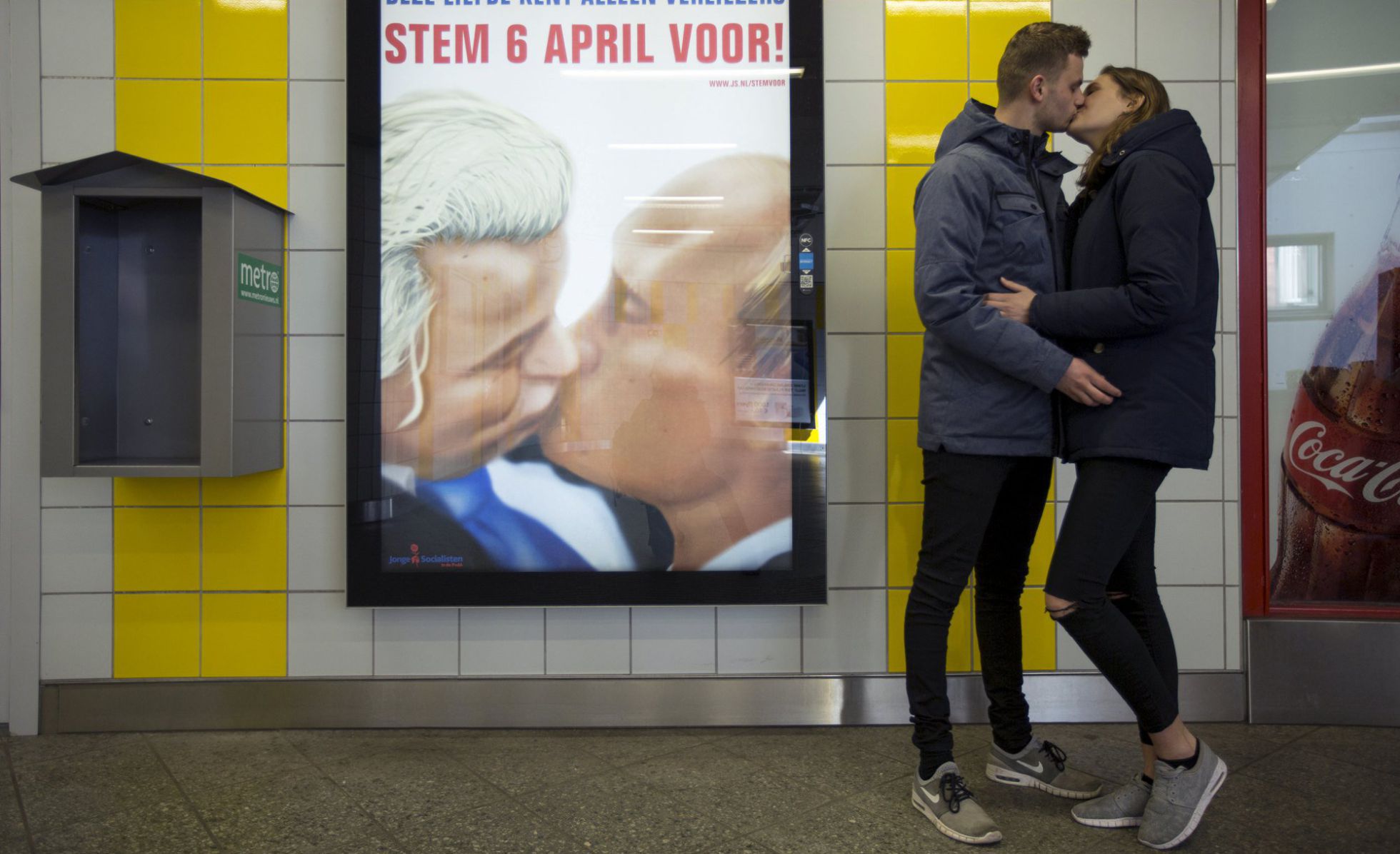 Una pareja se besa junto a un poster con una caricatura en la que el político holandés Geert Wilders besa al presidente ruso Valdímir Putin en el metro de Ámsterdam. Foto por Cris Toala Olivares, REUTERS