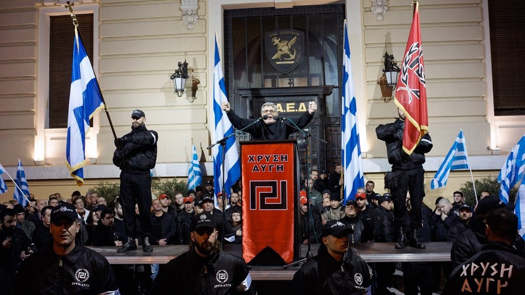 Members of the extreme-right Golden Dawn party stand around a stage while leader of the party Nikolaos Mihaloliakos delivers a speech during a gathering in Athens February 2, 2013. Photo by Milos Bicanski /Getty Images