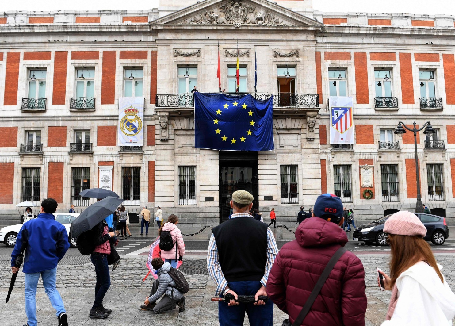 The European Union flag is displayed between two soccer club banners on the Royal Post Office, the seat of the office of the president of Madrid. (Gerard Julien/Agence France-Presse via Getty Images)