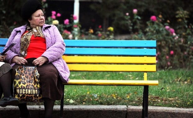 A woman sits on a bench painted in the colours of the Ukrainian national flag in Slavyansk, eastern Ukraine, on October 22, 2014. Ukraine's President Petro Poroshenko's party on October 22 led the final polls before Sunday's parliamentary vote held as the country faced an unresolved Russian gas dispute and raging hostilities in the east. AFP PHOTO / DOMINIQUE FAGET / AFP PHOTO / DOMINIQUE FAGET