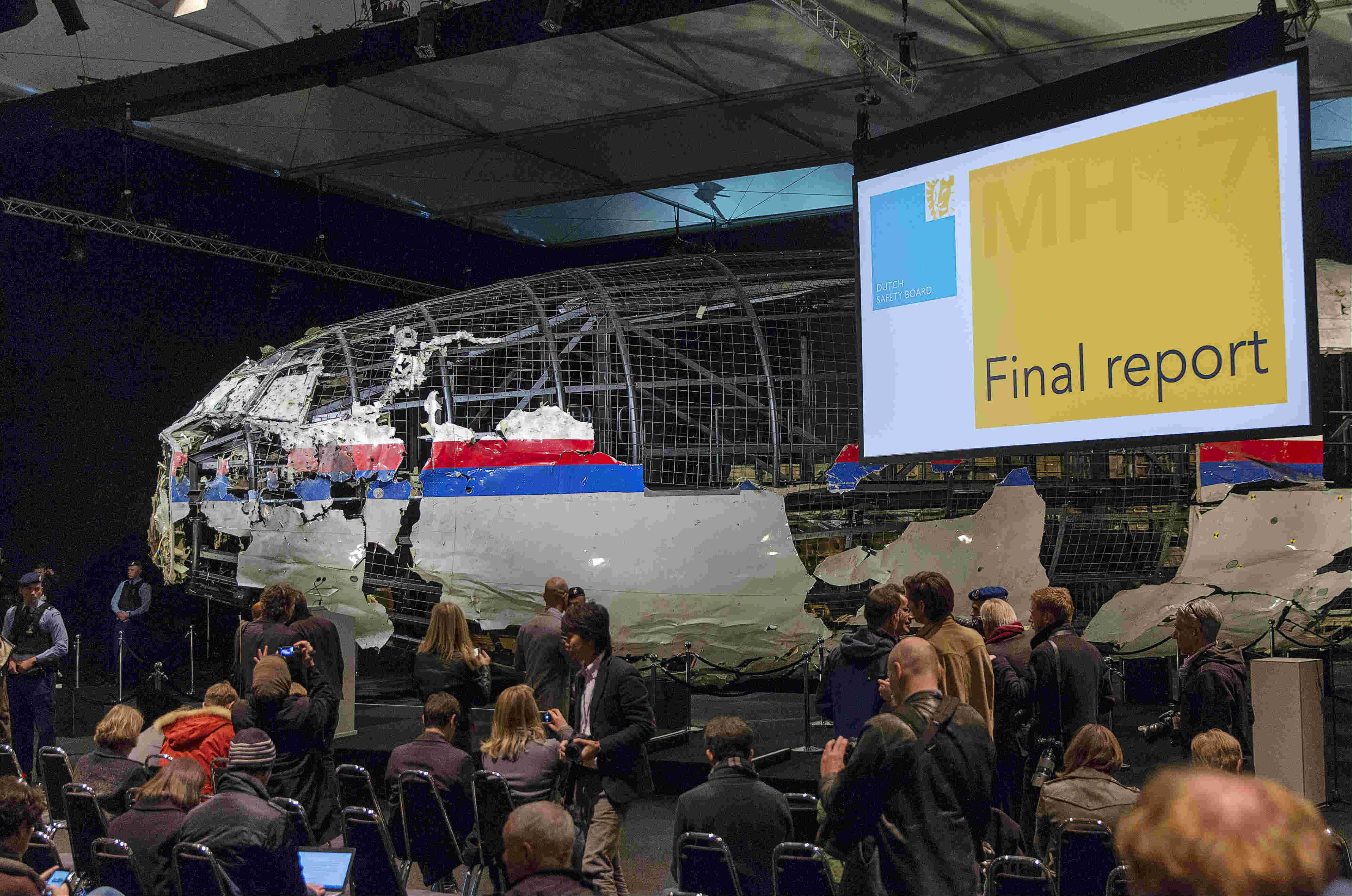 The reconstructed airplane serves as a backdrop during the presentation of the final report into the crash of July 2014 of Malaysia Airlines flight MH17 over Ukraine, in Gilze Rijen, the Netherlands, October 13, 2015. REUTERS/Michael Kooren