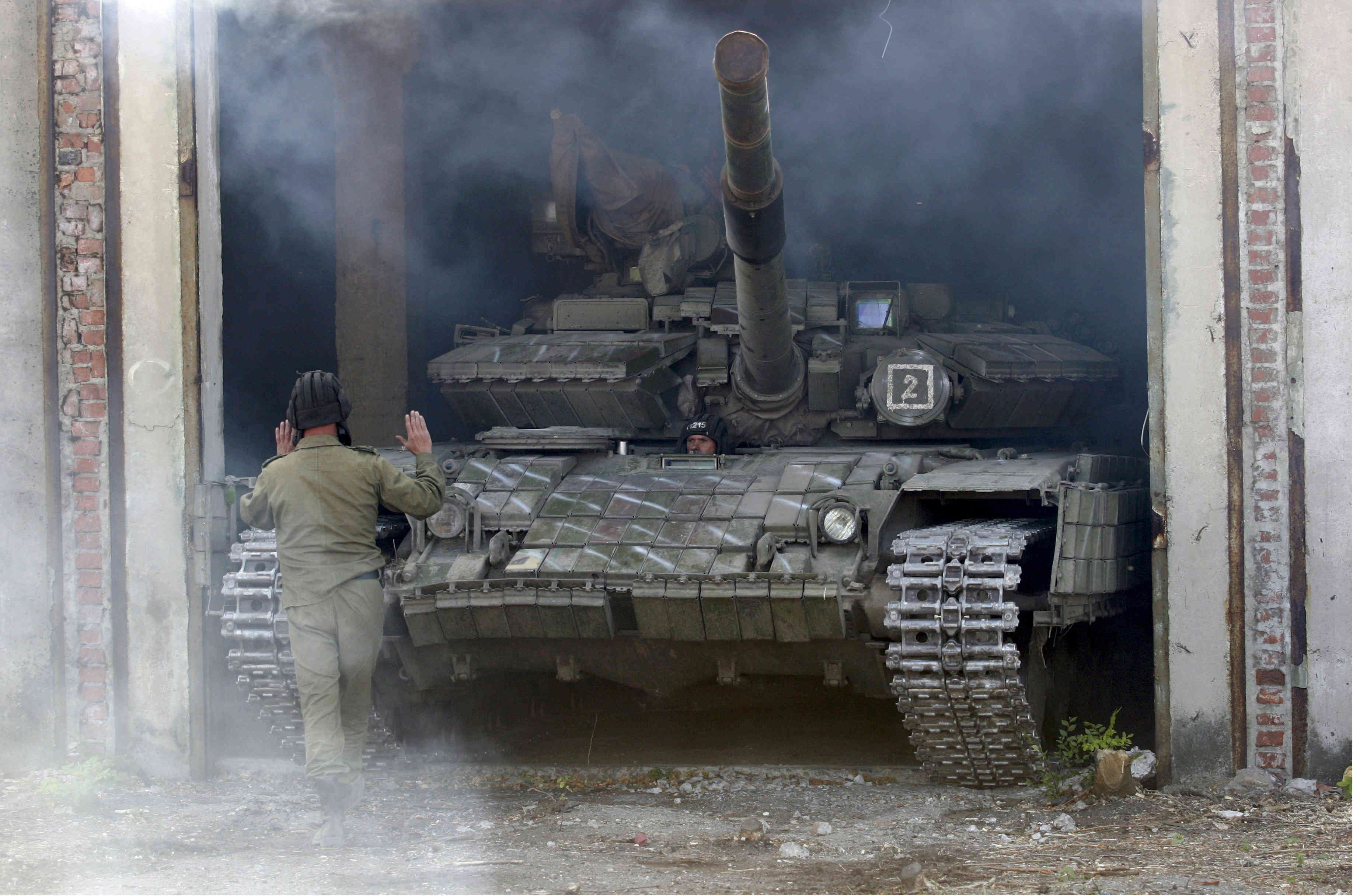 A member of the self-proclaimed Luhansk People's Republic (LNR) forces guides a tank to park after withdrawing it further from the frontline outside Luhansk, Ukraine, October 3, 2015. REUTERS/Alexander Ermochenko (Atlantic Council)