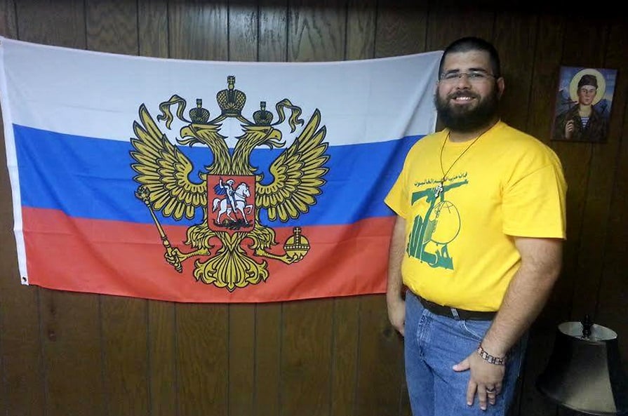 Matthew Heimbach stands next to a flag used to represent the president of Russia in a photo he published to his personal page on the Russian social media web site VKontakte in August 2015