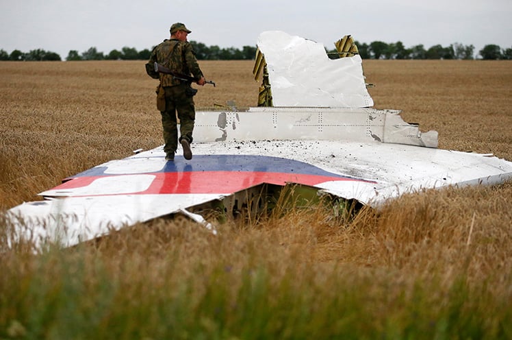 An armed pro-Russian separatist stands on part of the wreckage of the Malaysia Airlines Flight MH17 after it crashed in the Donetsk region in Ukraine on July 17, 2014. The Dutch are due to announce on September 28 the long-awaited results of an investigation with Australia, Malaysia, Belgium, and Ukraine into the downing of the aircraft. (Reuters/Maxim Zmeyev)